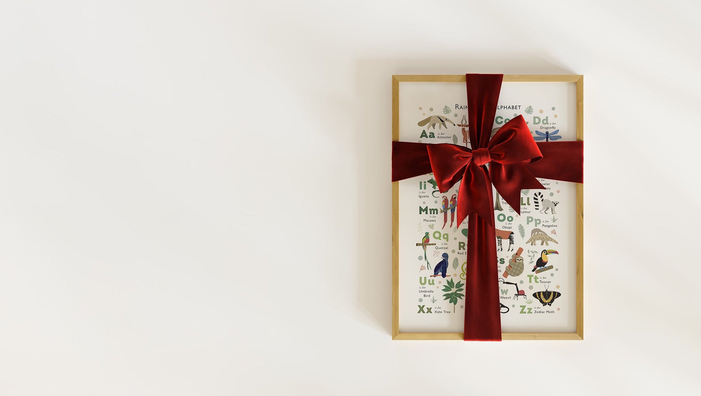 A collection of bestselling dinosaur-themed art prints, one framed and wrapped in a red ribbon, ready for Christmas gifting.