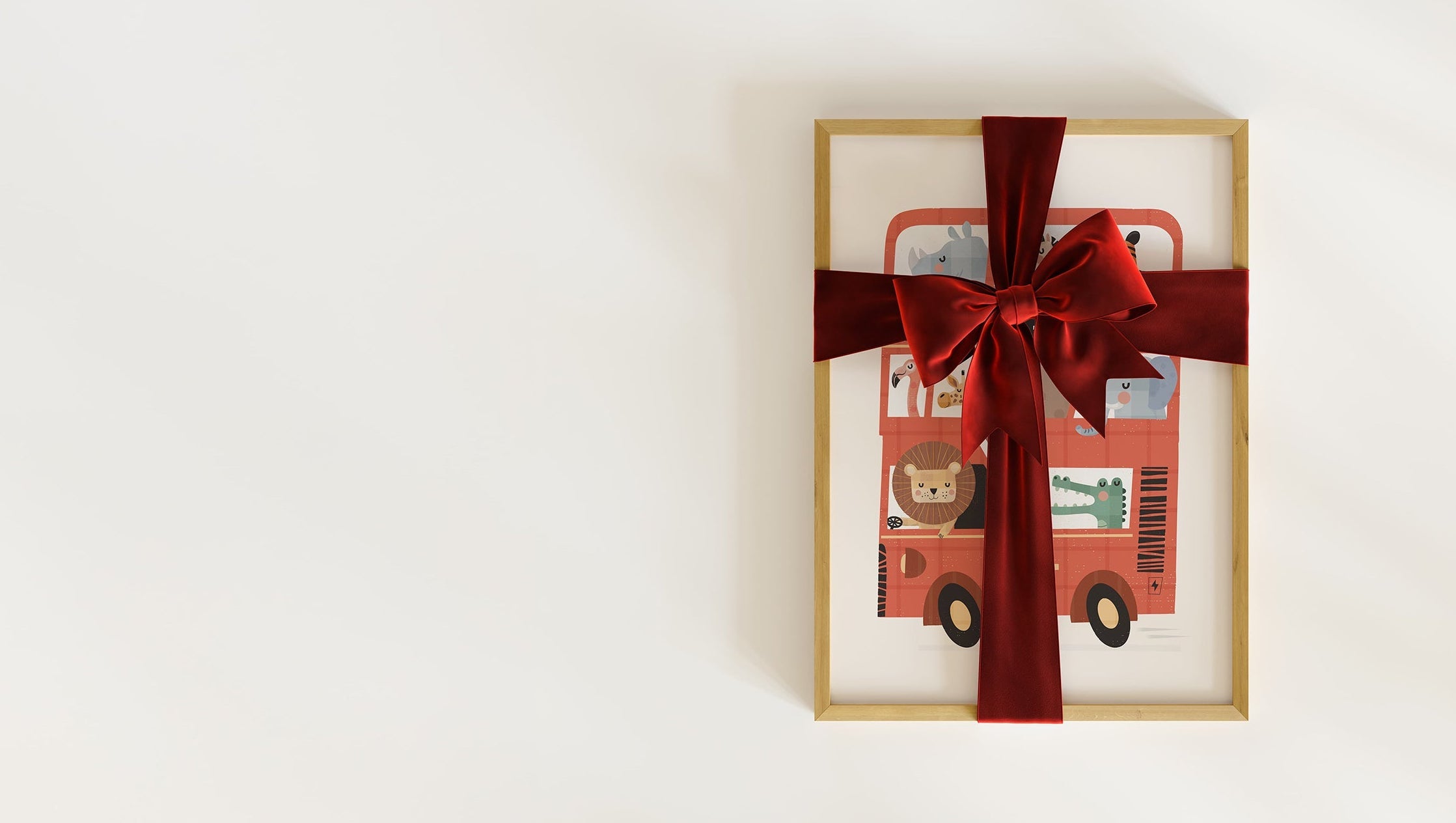 A framed art print featuring cute safari animals riding in a red london double-decker bus, wrapped in a red velvet ribbon for Christmas, a perfect personalised keepsake gift.