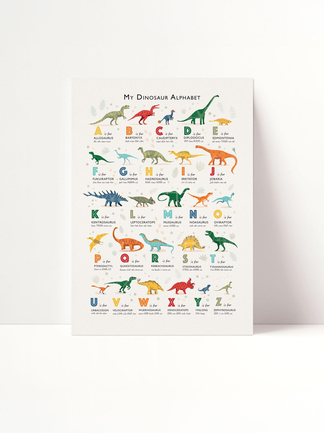 Personalised dinosaur alphabet print flat lay — illustrated dinosaur A to Z poster for children’s bedroom or learning corner.