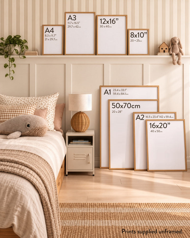 A styled bedroom scene showing multiple unframed picture frames with printed size labels in inches and centimeters, arranged against a cream paneled wall above a bed. The frames include A4, A3, 12x16, 8x10, A1, 50x70, A2, and 16x20.