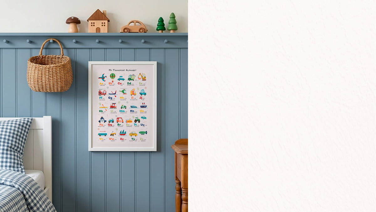A framed children's educational poster titled 'The Transportation World' hangs on a blue wood-paneled wall in a nursery setting, next to a wicker basket and above a bed with blue-and-white check bedding. The right side of the image is plain white.