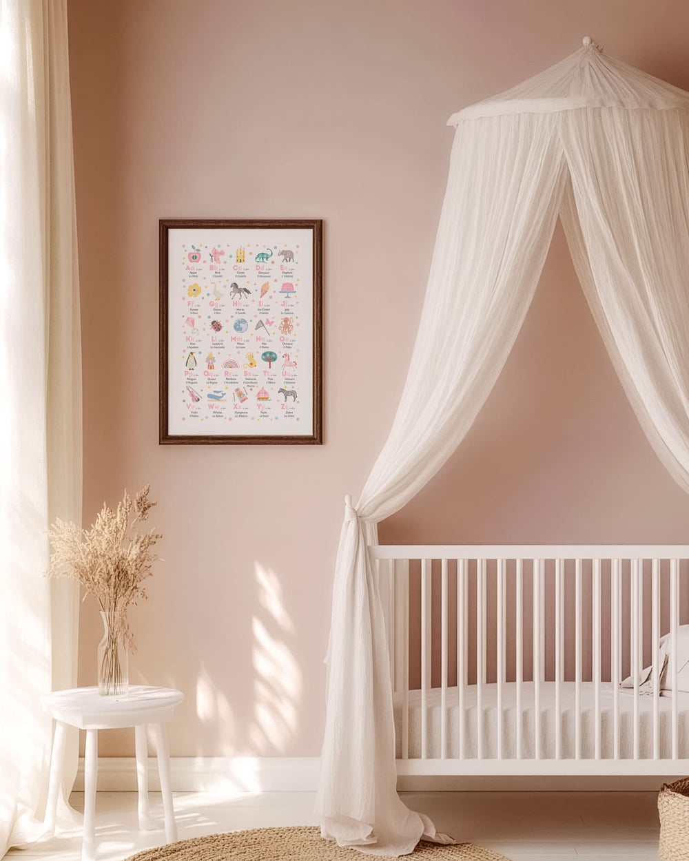 Blush Pink Nursery room with a crib, canopy, and framed bilingual alphabet chart on a wall.