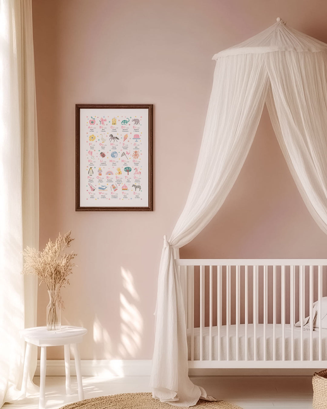 Blush Pink Nursery room with a crib, canopy, and framed bilingual alphabet chart on a wall.