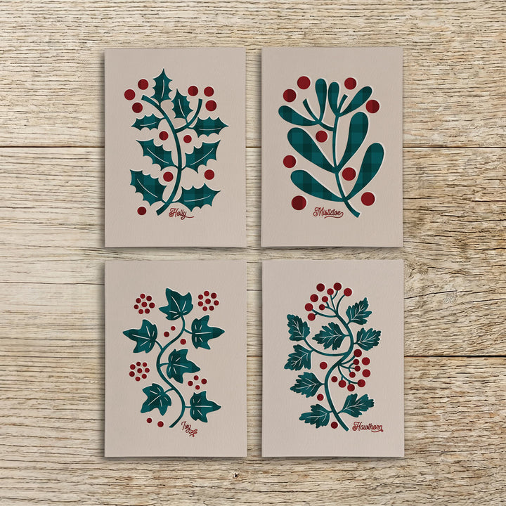 Four botanical Christmas cards featuring holly, mistletoe, ivy and hawthorn arranged together