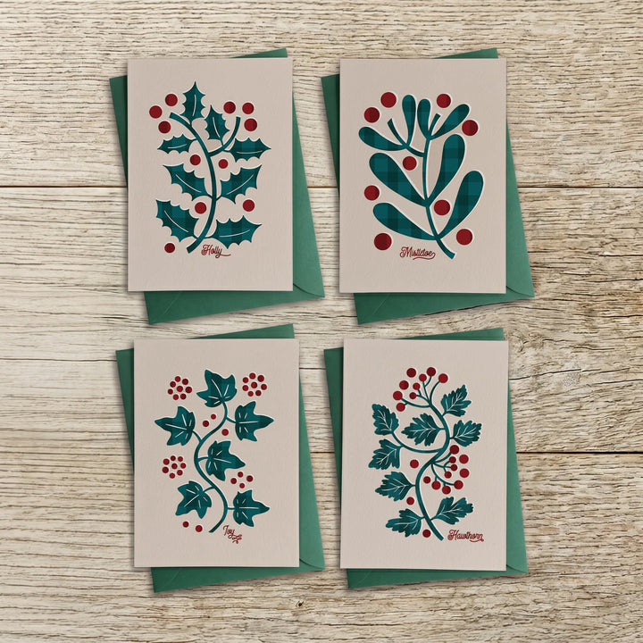 Set of four botanical Christmas cards with holly, mistletoe, ivy and hawthorn designs and green envelopes