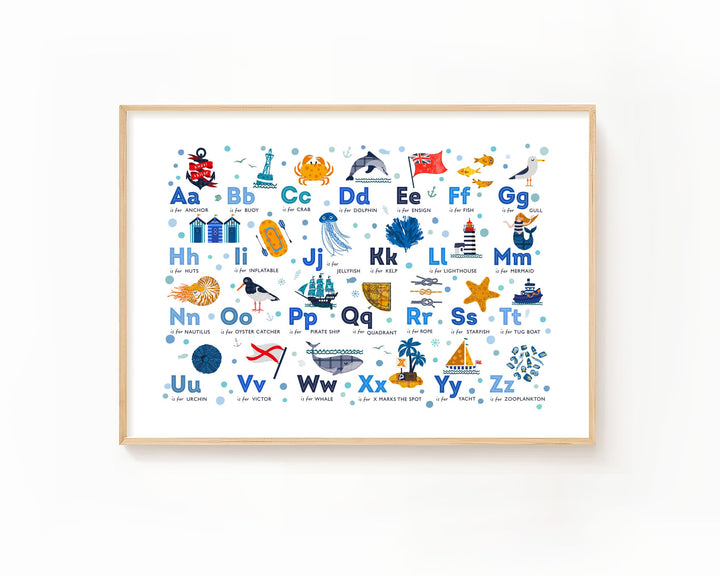 A framed alphabet art print featuring colorful educational illustrations for the alphabet, including letters, words, and sea and land animals, displayed on a clean white wall.