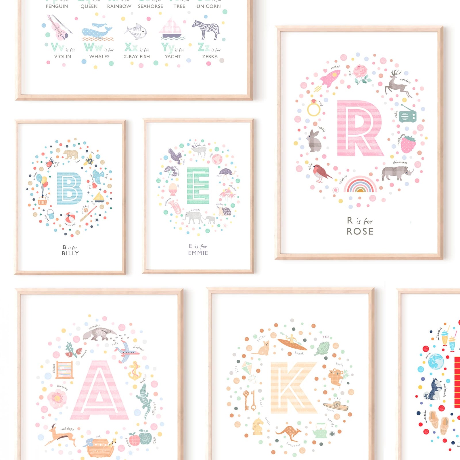 A selection of illustrated initial prints in various sizes and soft colours, each framed in natural oak and styled as a gallery wall for a modern nursery.