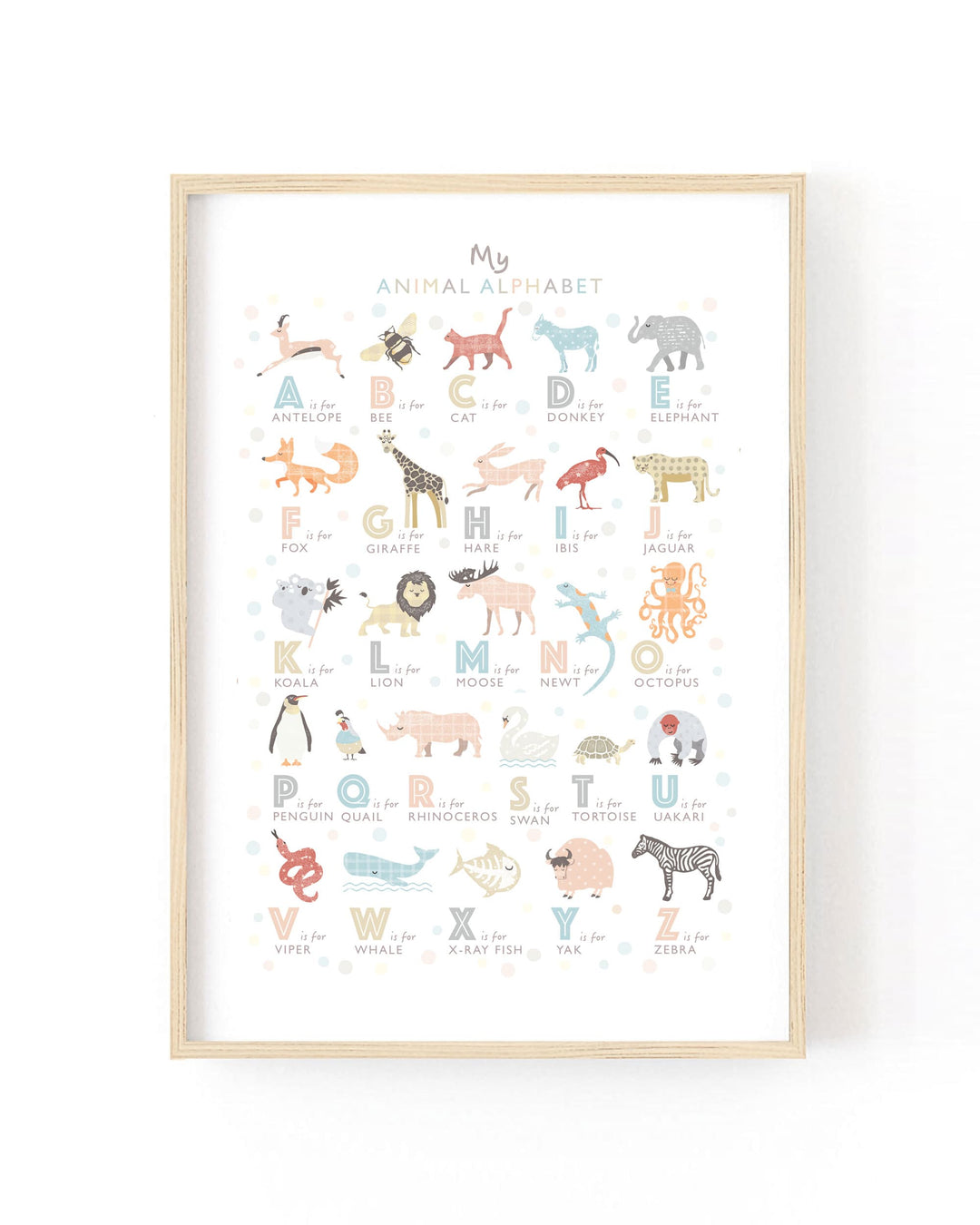 A framed children's alphabet art print titled 'My Animal Alphabet' featuring colorful animal illustrations paired with letters on a white background, shown in a light wood frame against a white wall.