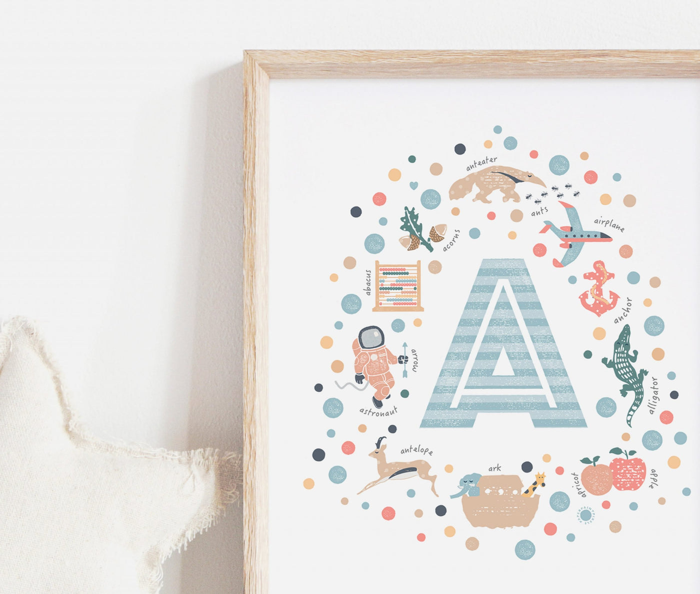 Personalised Boys Initial Letter Print - Letter A framed in oak resting against a wall next to a soft fabric star