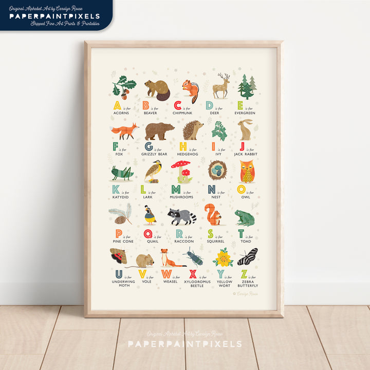 A printable woodland alphabet print, shown framed and styled in a calm, neutral nursery to showcase nature-themed decor ideas